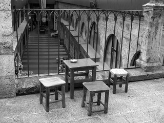 Tisch und Hocker für die Teepause im traditionellen Seidenbasar Koza Han an der Großen Moschee in der alten osmanischen Hauptstadt Bursa am Uludag Gebirge in der Türkei in neorealistischem Schwarzweiß © Martin Debus