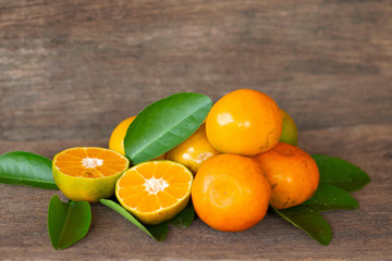  Ripe oranges and leaves on a wooden table, separate on the old wooden floor, sour fruit