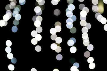 Unfocused abstract white bokeh on black background. defocused and blurred many round light