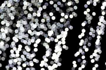Unfocused abstract white bokeh on black background. defocused and blurred many round light