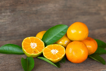  Ripe oranges and leaves on a wooden table, separate on the old wooden floor, sour fruit