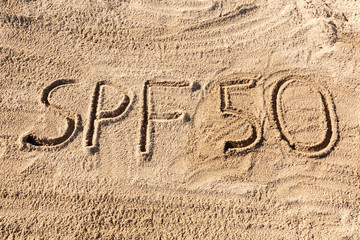 Sun protect factor fifty concept. SPF 50 word written on the beach
