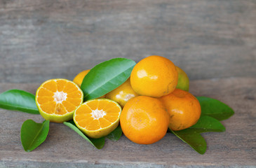  Ripe oranges and leaves on a wooden table, separate on the old wooden floor, sour fruit