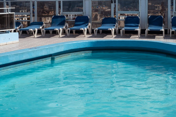 Deck chairs by blue pool in Havana, Cuba