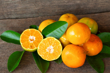  Ripe oranges and leaves on a wooden table, separate on the old wooden floor, sour fruit