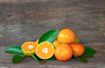  Ripe oranges and leaves on a wooden table, separate on the old wooden floor, sour fruit