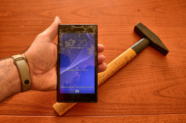 Close up on a smartphone screen with a broken screen and a thousand cracks