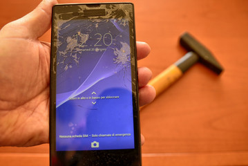 Close up on a smartphone screen with a broken screen and a thousand cracks