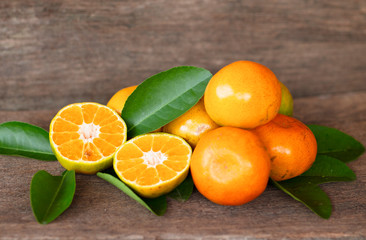  Ripe oranges and leaves on a wooden table, separate on the old wooden floor, sour fruit