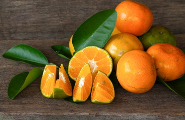  Ripe oranges and leaves on a wooden table, separate on the old wooden floor, sour fruit