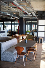 The eating and casual meeting area at a creative office in daylight, no people, vertical