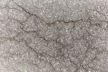 Cracked asphalt road on hot summers day.