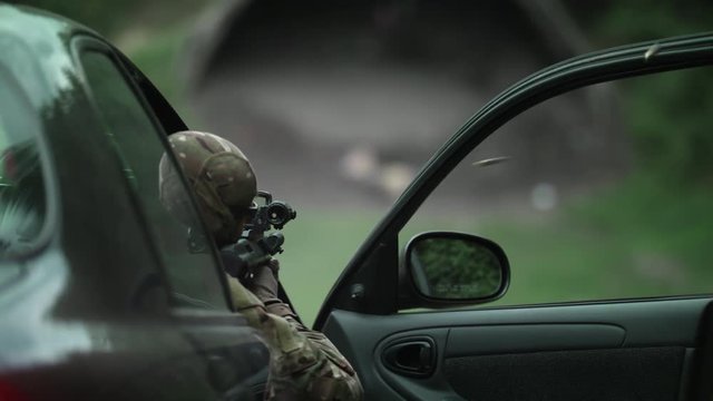 Shooting from a car, a policeman shoots a rifle. Fully equipped policeman, Slow Motion 4K UHD.