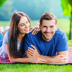 Picture of happy couple lying on a picnic blanket, square composition