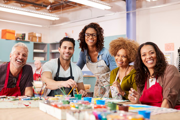 Portrait Of Mature Adults Attending Art Class In Community Centre With Teacher