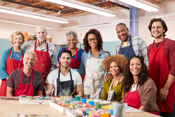 Portrait Of Mature Adults Attending Art Class In Community Centre With Teacher