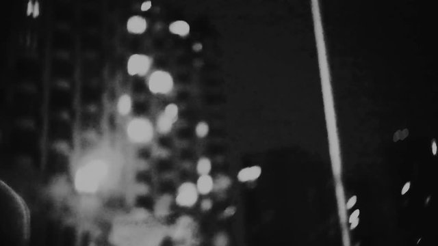 Blurred urban night life motion background loop. Ghetto street lights -  defocused dynamic hyper lapse. Big dirty city location.