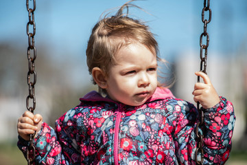 niña rubia juega parque hamaca plaza verde