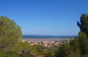 Top view of the old European city with red roofs near the sea in the summer on the southern island.