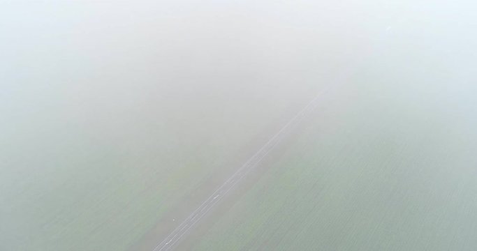 Through the clouds to the highway, green fields