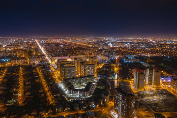 Fototapeta na wymiar Aerial cityscape panoramic view, flight on drone above night city Voronezh with illuminated roads and high-rise buildings