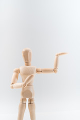 Wooden dummy proudly presents some invisible thing, isolated on white background, copy space for your object or text