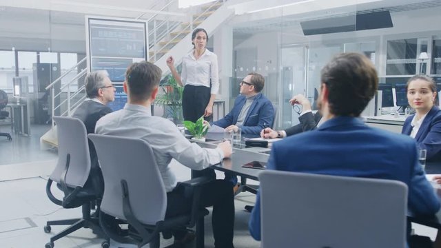 In the Corporate Meeting Room: Female Executive Uses Digital Interactive Whiteboard for Presentation to a Board of Directors, Lawyers, Investors. Screen Shows Company Growth Data with Animated Graphs