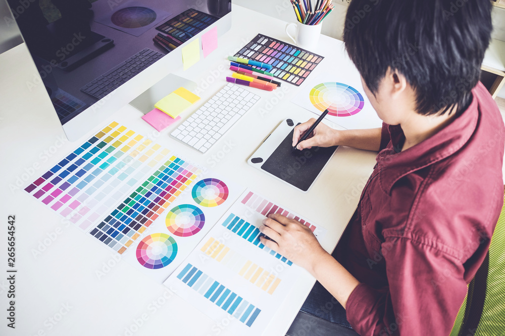 Poster High angle view of female graphic designer working on color selection and drawing on graphics tablet at workplace