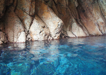 Grotto in the lagoon with azure blue transparent water with stones and rocks.