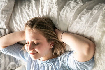 A teenage girl lying in bed and relaxing