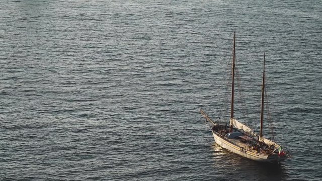 Yacht in the Mediterranean Sea at sunset, luxury travel tour, space for text, summer, ocean surface, water transport, fishing, vacation, two-masted yacht,