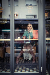 Fototapeta na wymiar Young Fashion Girl In Caffe Store Window
