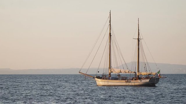 Yacht in the Mediterranean Sea at sunset, luxury travel tour, space for text, summer, ocean surface, water transport, fishing, vacation, two-masted yacht,