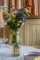 Small vase of flowers on white table cloth