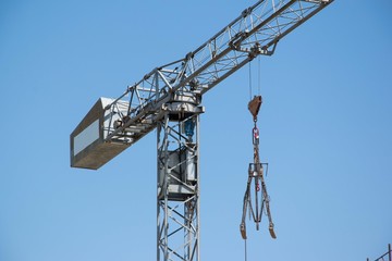 Naklejka premium Detail of a construction crane lifting construction equipment