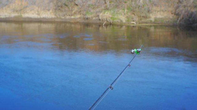 End of the fishing rod with a bell bent from the bite of a fish on feeder fishing.1920X1080 Full Hd.