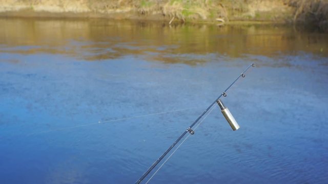 End of the fishing rod with a bell bent from the bite of a fish on feeder fishing.1920X1080 Full Hd.