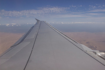 Fototapeta na wymiar airplane wing and desert from the airplane window