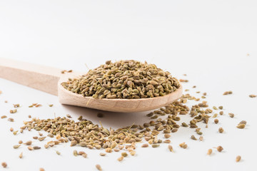 Anise seeds on wooden spoon on white background