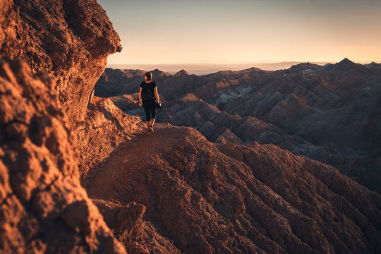 Woman hiking through the mountains of Atacama desert during sunset