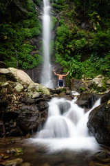Obraz premium Beautiful scene of Semirang Waterfall with lovely smooth water. A man standing and enjoying a gorgeous waterfall. A Waterfall which is a tourist destination in the city of Ungaran