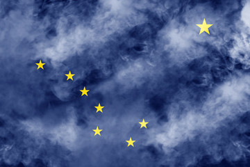 The national flag of the US state Alaska in against a gray smoke on the day of independence in different colors of blue red and yellow. Political and religious disputes, customs and delivery.