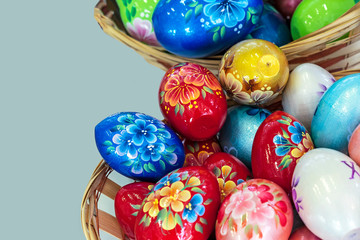 Fototapeta premium Colorful Easter eggs in a wicker basket on a gray background.