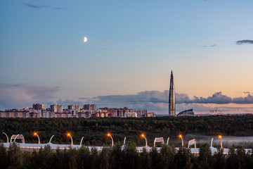 Obraz premium Evening cityscape. View of the Lakhta Center tower in St. Petersburg in the sunset with clouds and moon
