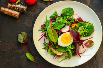 salad with egg, radish, lettuce, arugula, spinach and other leaves (snack). food background. top