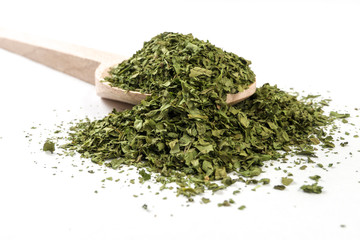 coriander leaves on wooden spoon on white background