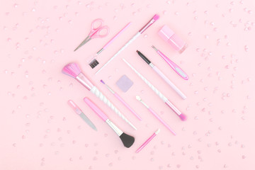 Feminine accessories and unicorn makeup brushes centured on pink background. Flat lay with copy space, beauty and cosmetics blogger concept