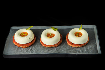 three mini white mousse cakes with orange jam filling