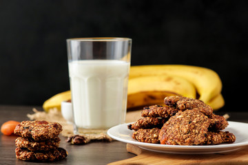 healthy food homemade oat flakes cookies on plate bananas glass of milk selective focus