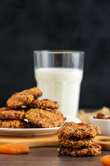 oat flake cookies glass of milk on black background vertical orientation soft focus